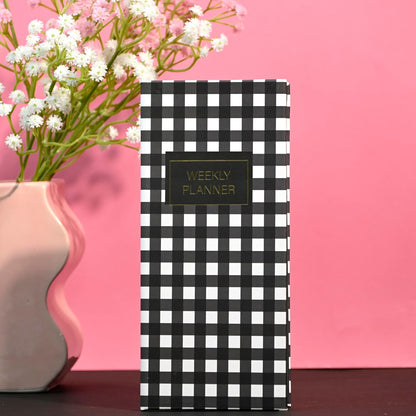 Black and white checkered planner with 'Weekly Planner' label on a pink background