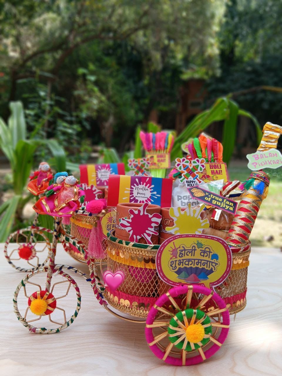 Decorative toy cart with colorful items on a wooden surface