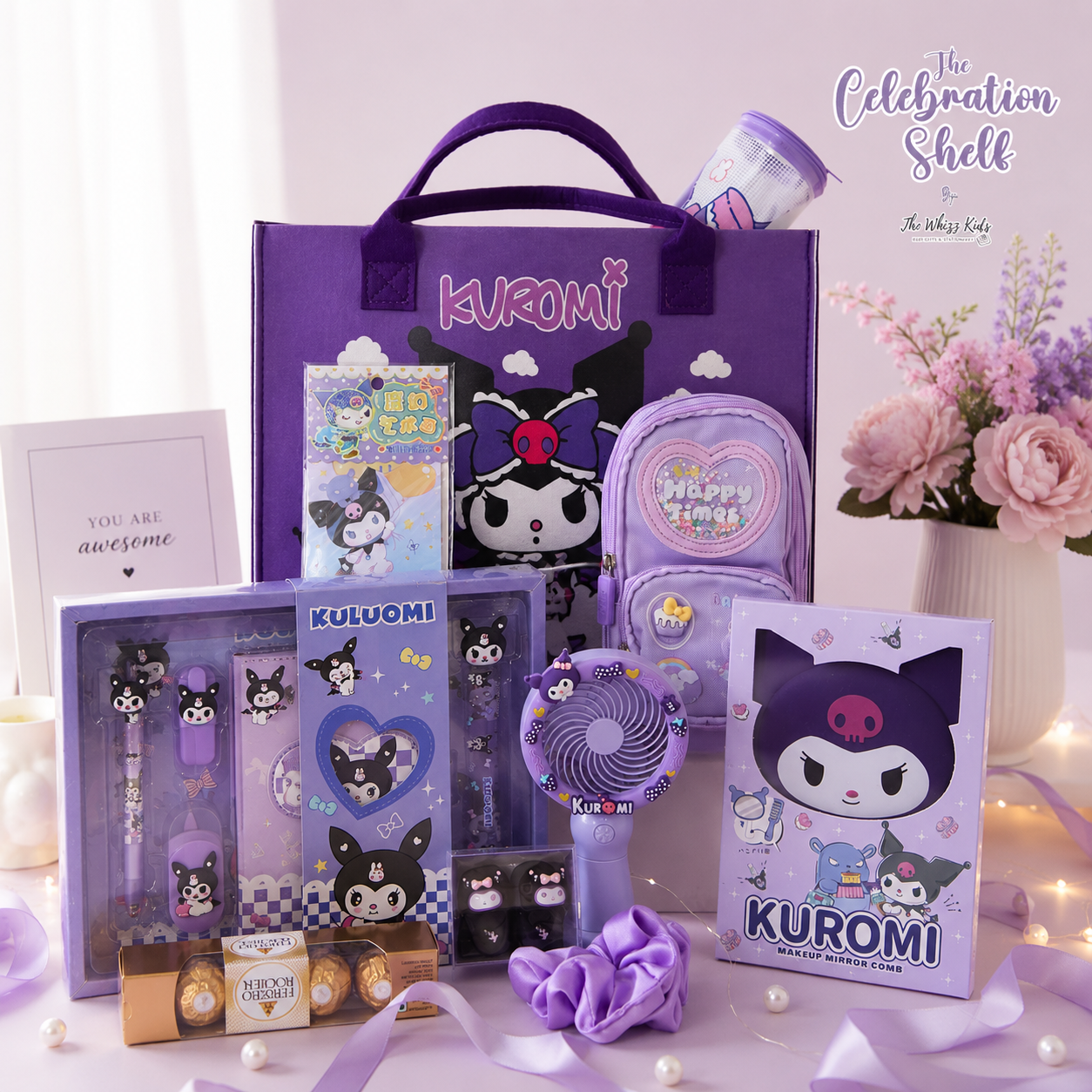 A curated Kuromi-themed stationery and accessory gift set arranged on a pale pink surface. Visible items include a large purple tote bag, a purple backpack, a clear pen set in a lavender box, a small purple handheld fan, a Kuromi card, and other matching accessories.