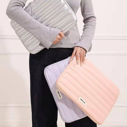 Person holding two inflatable travel cases, one white and one pink, against a light background.