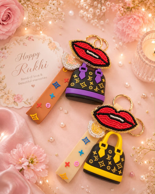 Two beaded keychains styled as red lips with Louis Vuitton monogram bags, displayed on a pink floral background with a 'Happy Rakhi' card and decorative lights.