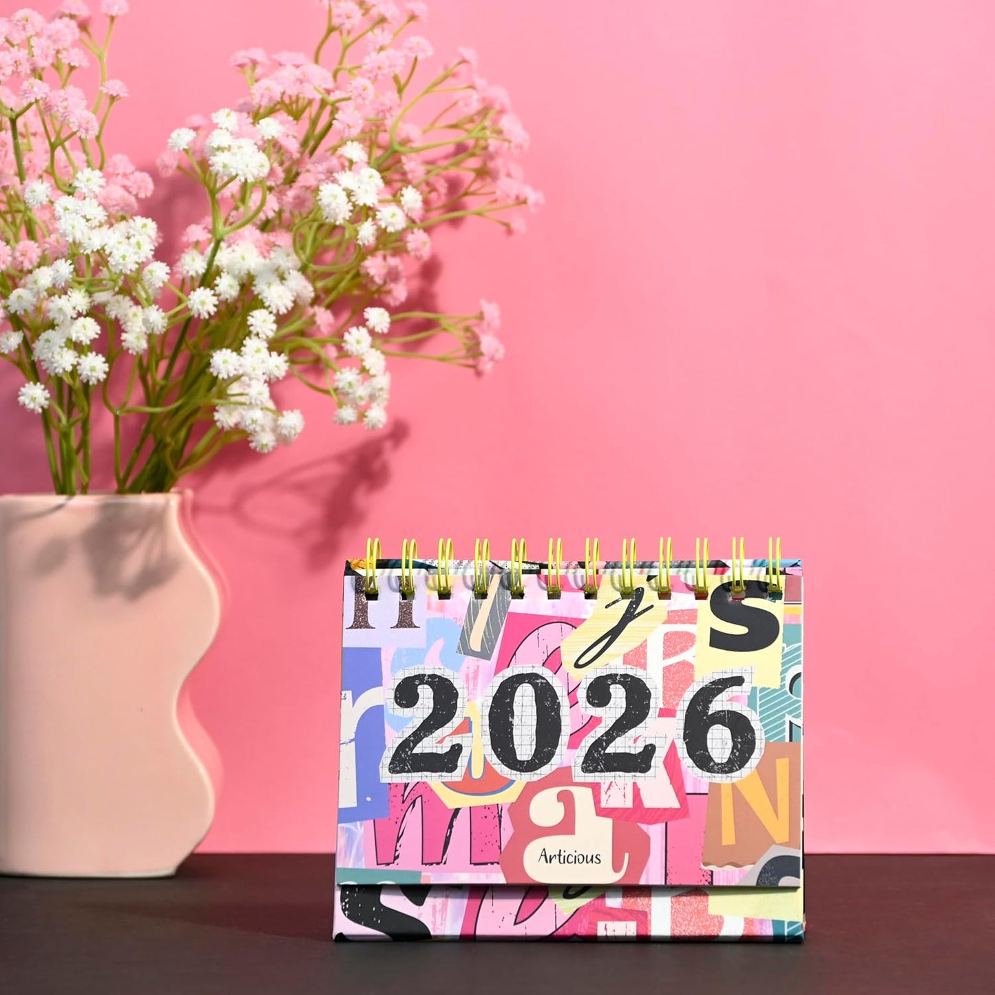 Colorful 2026 calendar with a vase of flowers on a pink background
